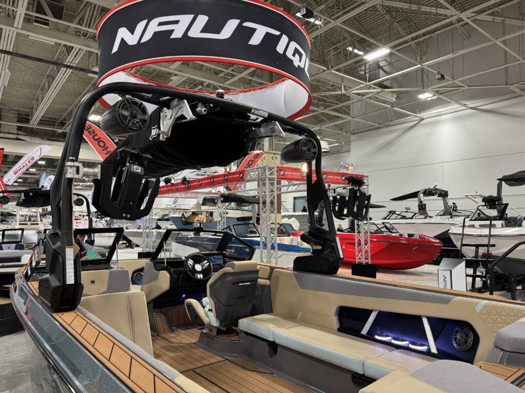 Interior of a Nautique wake boat on display at the Milwaukee Boat Show featuring luxury seating, premium audio, and a wake tower.